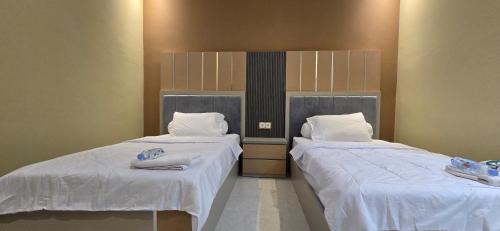 two beds sitting next to each other in a room at Hotel Tian in Nabire