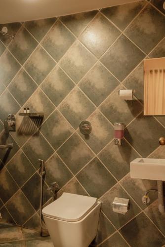 a bathroom with a toilet and a sink at Wild Woods Tiger Resort in Nagpur