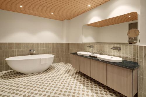 a bathroom with two sinks and a large mirror at Treat Resort Rajkot in Rajkot