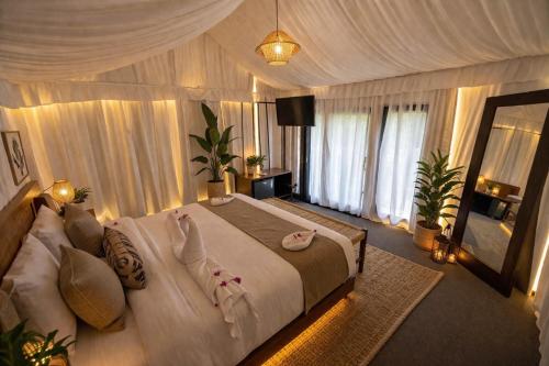 a bedroom with a large bed with pillows on it at Badi Meadows By Wilkisto Near Fatehsagar Lake in Udaipur