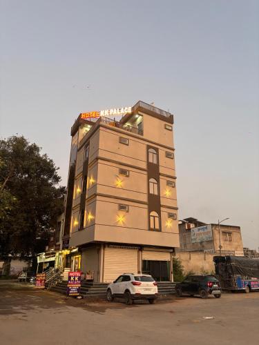 a tall building with cars parked in front of it at Hotel KK Place in Chittaurgarh