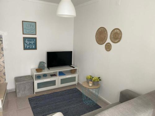 a living room with a flat screen tv on a wall at Casa BeijoMar in Nazaré