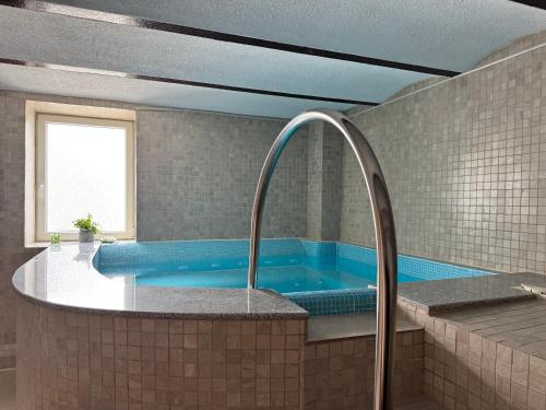 a large blue tub in a bathroom with a window at La Romică in Mediaş