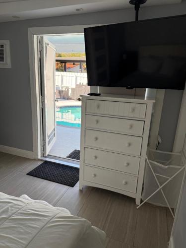 a bedroom with a dresser with a television on it at Room in Miami