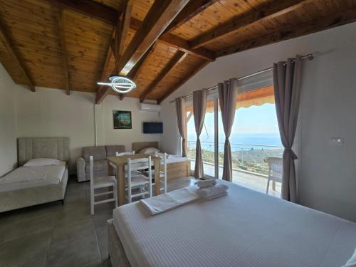 a bedroom with a bed and a table with a view at Arthur's 4Apartments in Borsh