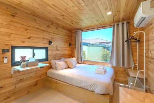 ein Schlafzimmer in einer Blockhütte mit einem Bett und einem Fenster in der Unterkunft Chambers in Phuket