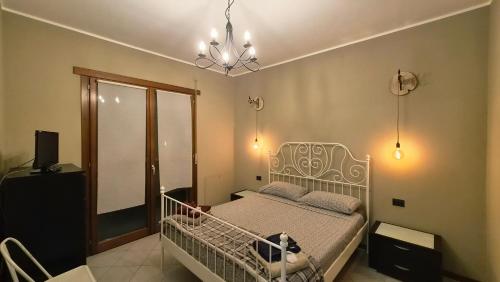a bedroom with a bed and a chandelier at IL NIDO - Intero Appartamento Forum & Humanitas in Rozzano