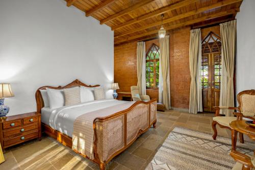 a bedroom with a bed and a table and chairs at The Postcard Saligao, North Goa in Calangute