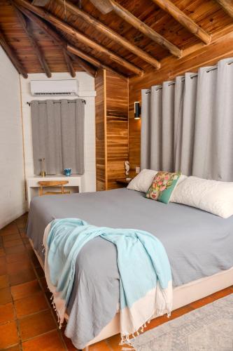 a bedroom with a large bed in a room with wooden ceilings at Quinta Esencia in Brasilito