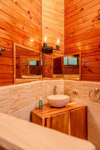 a bathroom with a sink and wooden walls at Quinta Esencia in Brasilito