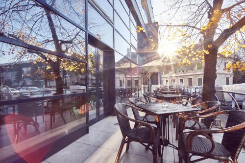 a patio with tables and chairs outside of a building at MyContinental Sibiu in Sibiu