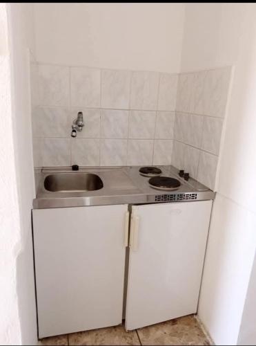a small kitchen with a sink and a stove at Apartmani Marija Rtina in Rtina