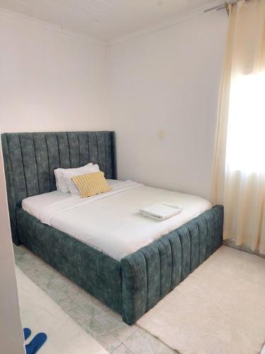 a bed in a room with a green headboard at JJHomes in Eldoret