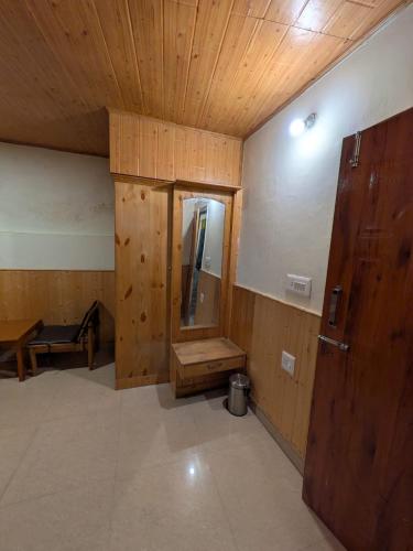 an empty room with a mirror and a wooden door at Misfits Hostel and Cafe in Shoja