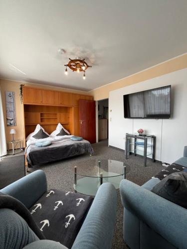 a living room with a couch and a table at Studio Heimi I mit Balkon strandnah Cuxhaven-Grimmershörnerbucht in Cuxhaven