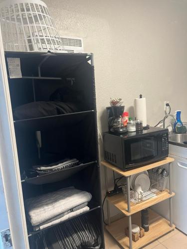 a kitchen with a microwave on a shelf with towels at Room in Miami