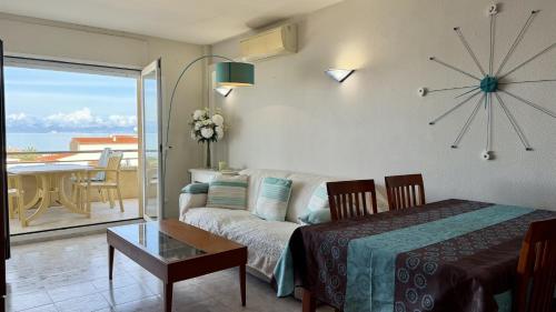 a living room with a couch and a clock on the wall at La Llongada 2-C in L'Escala