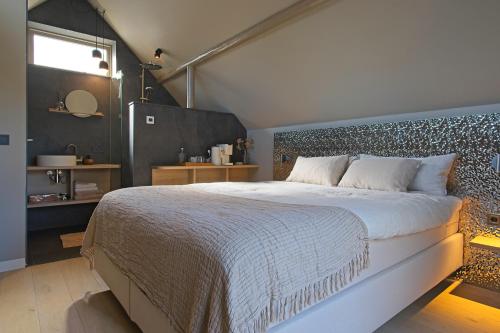 a bedroom with a large bed and a window at Boutique Hotel AEST Terschelling in Hoorn