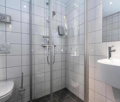 a bathroom with a shower and a toilet and a sink at Thon Hotel Nidaros in Trondheim