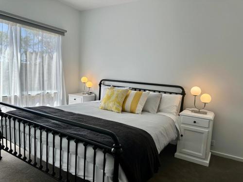 a bedroom with a bed with two night stands and two lamps at The Blue Nest, Clare in Clare