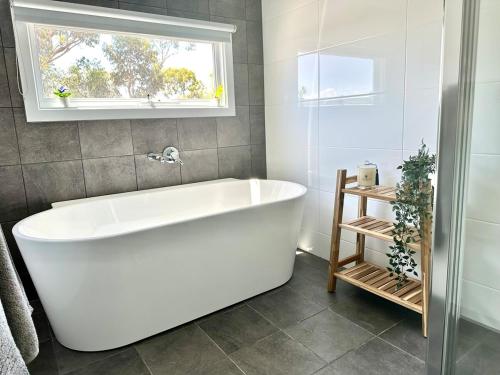 a white bath tub in a bathroom with a window at The Blue Nest, Clare in Clare