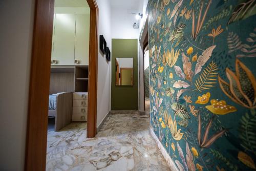 a hallway with a wall with a floral wallpaper at Mi casa tu casa - Guest House in Catania
