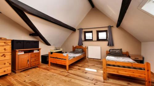 a attic room with two beds and a desk at Vakantie & wellness Erezee in Érezée