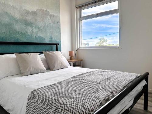 a bedroom with a large bed with a window at Seaside Serenity at Ocean Days in Brading