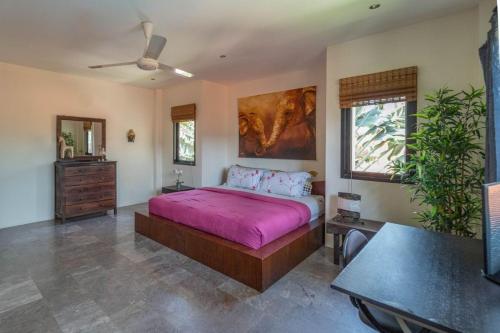 a bedroom with a large bed with a pink blanket at Malee Beach C8 in Phra Ae beach