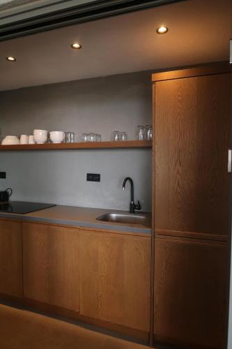 a kitchen with a sink and wooden cabinets at Yalikavak Manzarali Villa in Bodrum City