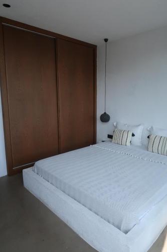 a bedroom with a large white bed with a wooden headboard at Yalikavak Manzarali Villa in Bodrum City