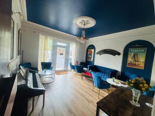 a living room with blue chairs and a blue ceiling at The Great Western B&B in Paignton
