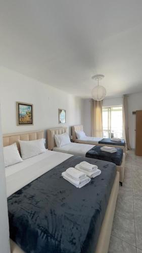 a bedroom with two beds and a living room at Emy's Rooms in Himare