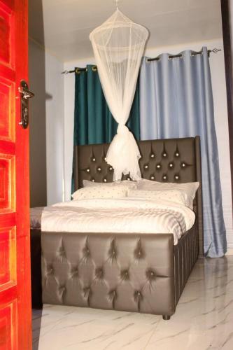 a bedroom with a bed with a mosquito net at Peaceful Home Self-catering Solar Backed Apartment in Lusaka
