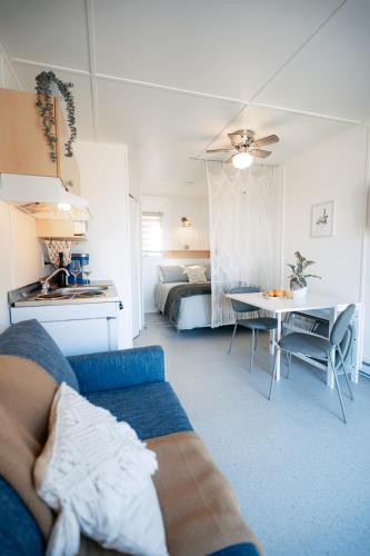 a living room with a couch and a bed and a table at Navigateur Ste-Luce in Sainte-Luce-sur-Mer