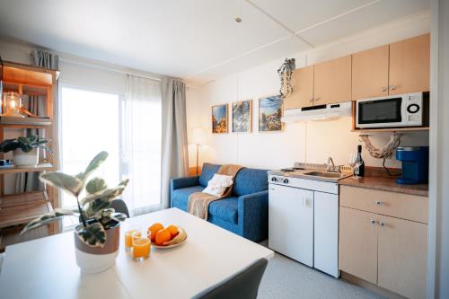 a kitchen and living room with a couch and a table at Navigateur Ste-Luce in Sainte-Luce-sur-Mer