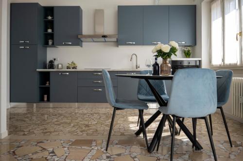 a kitchen with blue cabinets and a table and chairs at Dimora Francesco in Domodossola