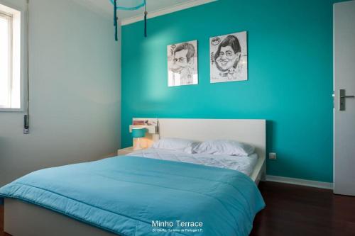 Un dormitorio con una pared azul y una cama en Minho Terrace, en Caminha