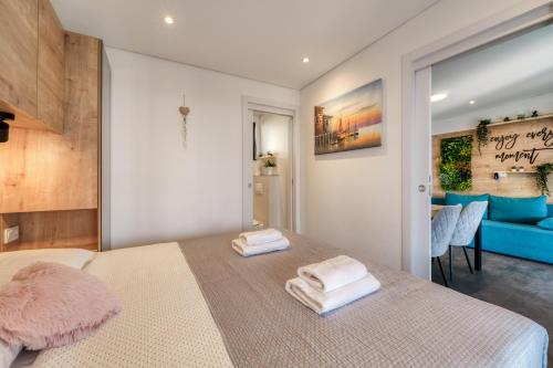 a bedroom with a bed with two towels on it at Sea view SanNor by Vellaris, Luxury Mobile Home in Mali Lošinj