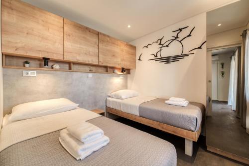 a bedroom with two beds and a wall at Sea view SanNor by Vellaris, Luxury Mobile Home in Mali Lošinj