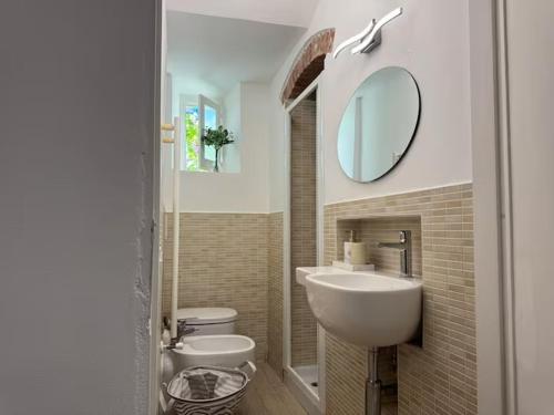 a bathroom with two toilets and a sink and a mirror at SOBBORGO 34 - Affittacamere - in Sarzana
