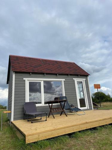 a house with a deck with two chairs and a table at Atpūtas vieta Friči in Līguti