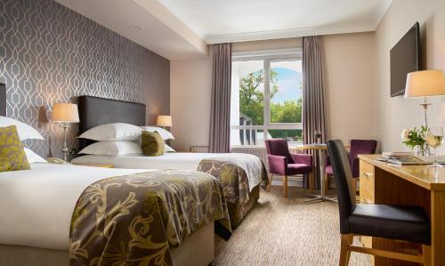 a hotel room with two beds and a desk at The Rine in Newmarket on Fergus