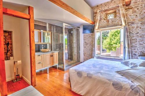 a bedroom with a large bed and a large window at Le Triol in Les Fournials