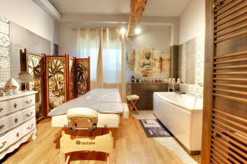 a bedroom with a bed and a tub and a sink at Le Triol in Les Fournials