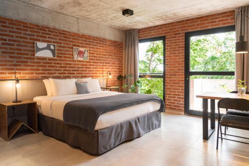 a bedroom with a bed and a brick wall at H5063 in Buenos Aires