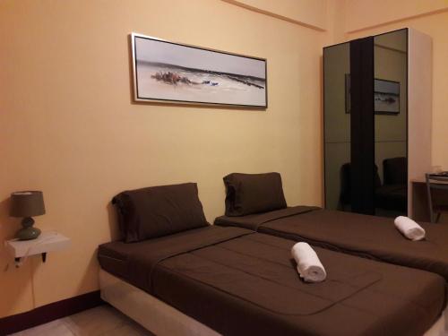 a bedroom with two beds and a picture on the wall at Navavilla Serviced Apartment in Ban Lam Rua Taek