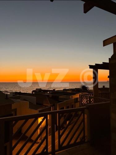 a view of the ocean from a balcony at sunset at Dolphin View 32 in Langstrand
