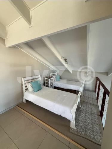 a bedroom with two beds in a attic at Dolphin View 32 in Langstrand