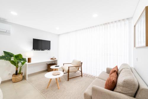a living room with a couch and a chair at Big Waves Retreat Nazaré - By Nest & Co in Nazaré